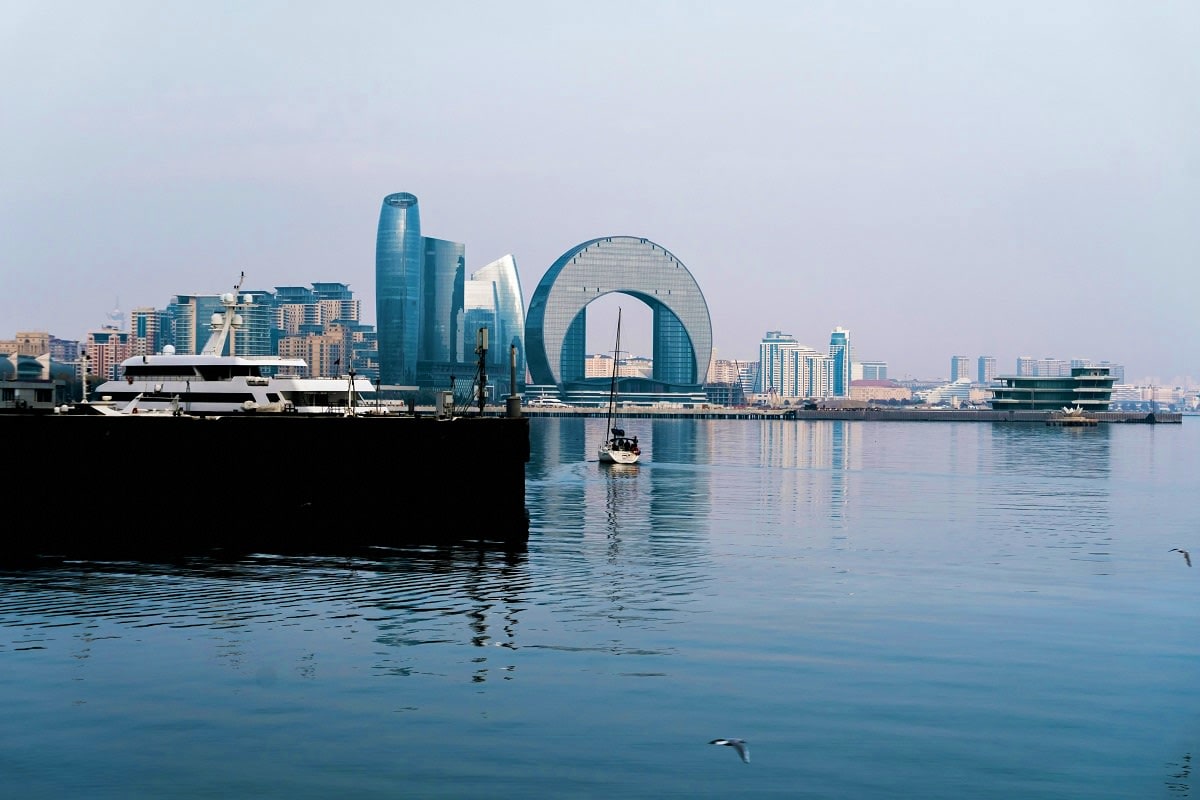 Classic Azerbaijan with Gabala Baku waterfront skyline featuring modern glass skyscrapers and the iconic Heydar Aliyev Center with its distinctive curved ar