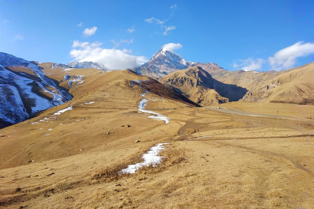 Snow-capped Himalayan mountain peak rising above arid valleys with melting snow streams in the Ladakh region along the Srinag