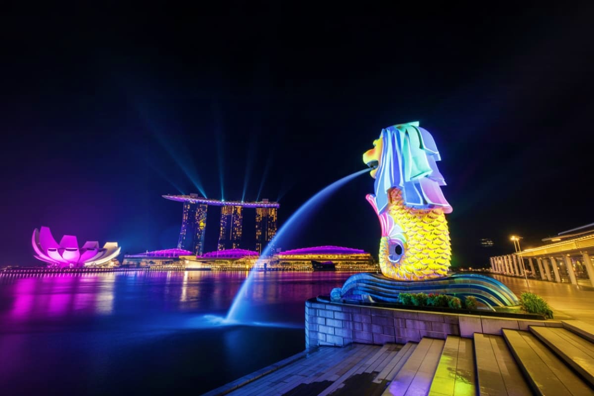 Singapore-Family-Fun-Package Merlion statue with water fountain illuminated at night with Marina Bay Sands hotel in background, Singapore