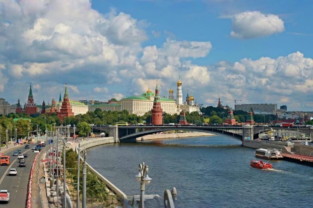 Moscow Kremlin and cityscape with Moscow River, bridge, and golden domes of Orthodox churches under blue sky with white cloud
