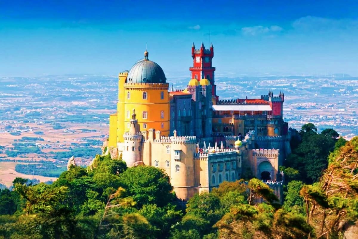 Pena Palace in Sintra, Portugal with colorful yellow, red and blue towers overlooking the countryside landscape