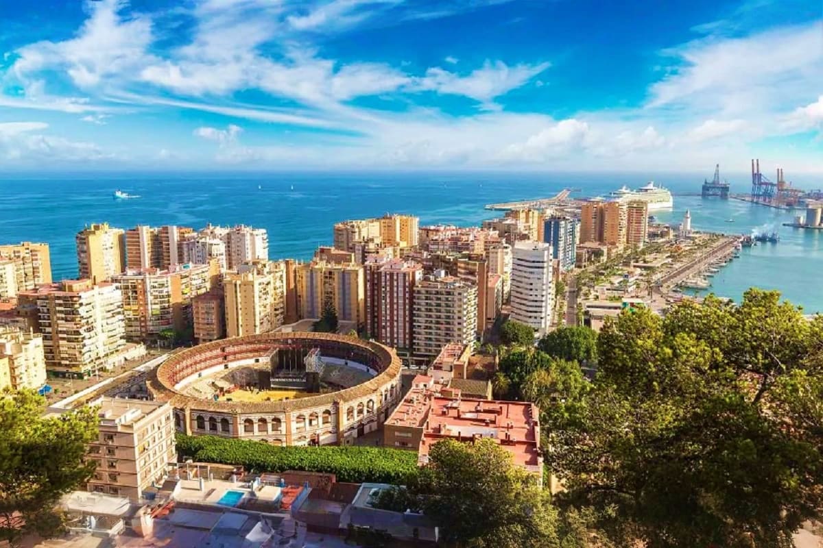 Aerial view of Malaga's historic bullring with Mediterranean Sea, beaches, and port in background, Spain