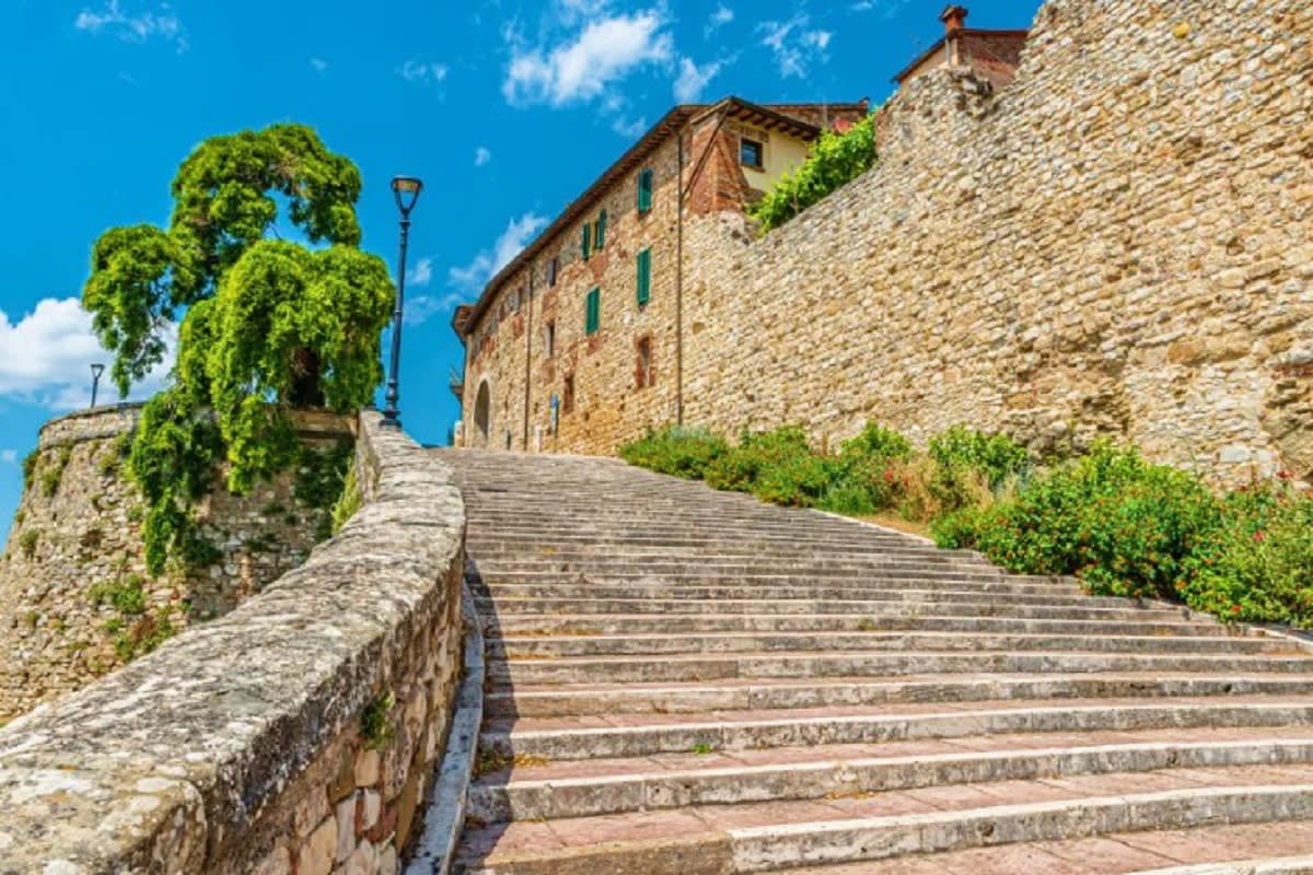The Essential of Italy Stone staircase leading to a historic Italian villa with ivy-covered walls under a blue sky