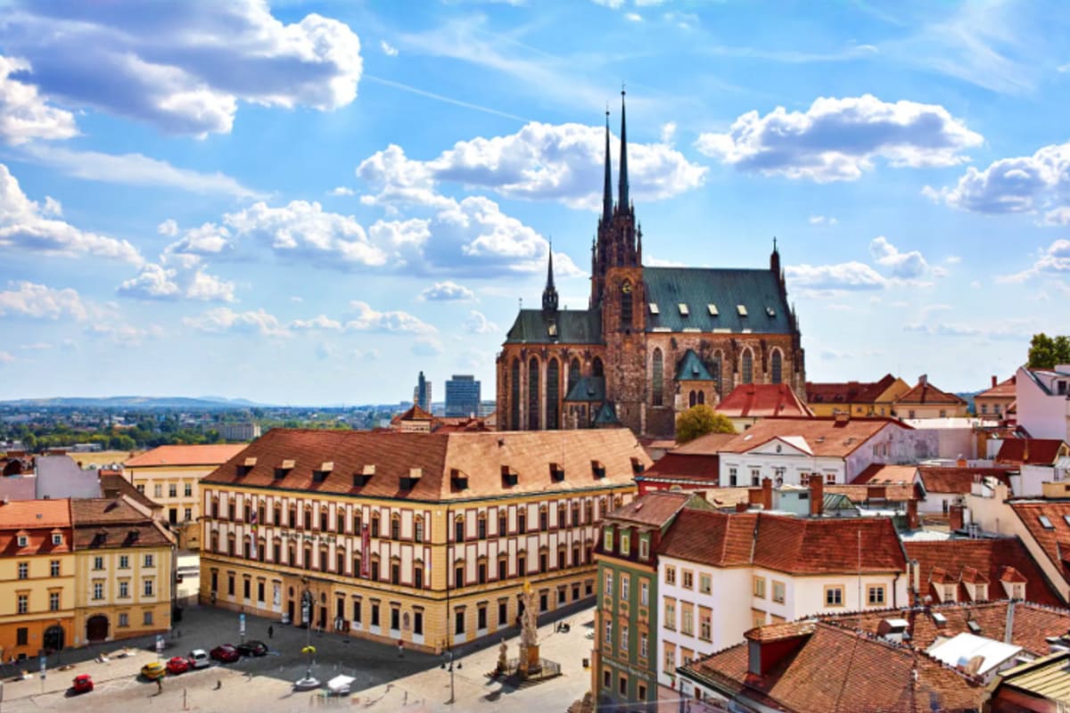 Historic city square in Brno, Czech Republic with Gothic cathedral and traditional European architecture under blue sky