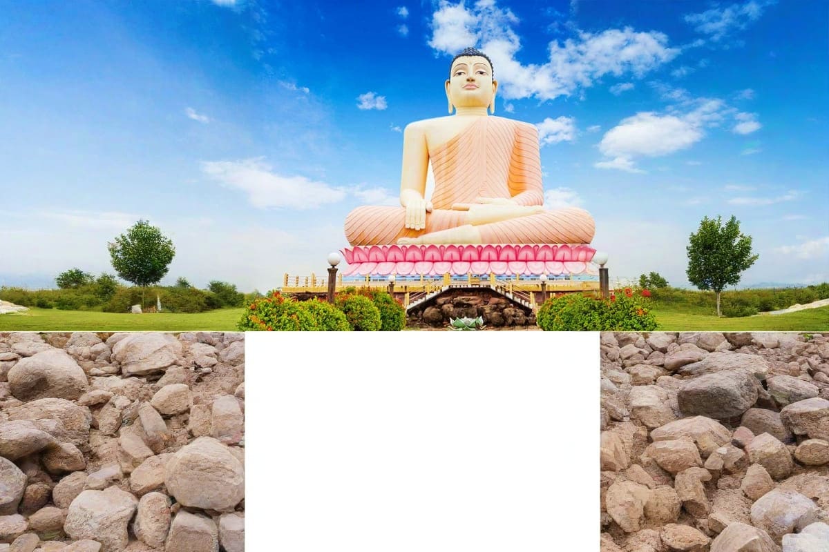 Giant white Buddha statue in saffron robes seated on pink lotus platform against blue sky with green landscape and stone wall