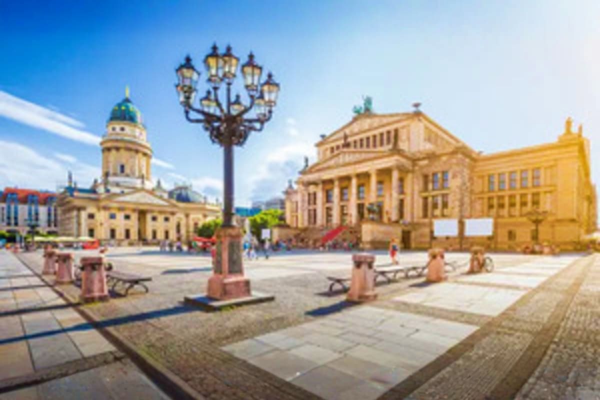 Gendarmenmarkt square in Berlin with French Cathedral, Concert House, and ornamental street lamp under blue sky
