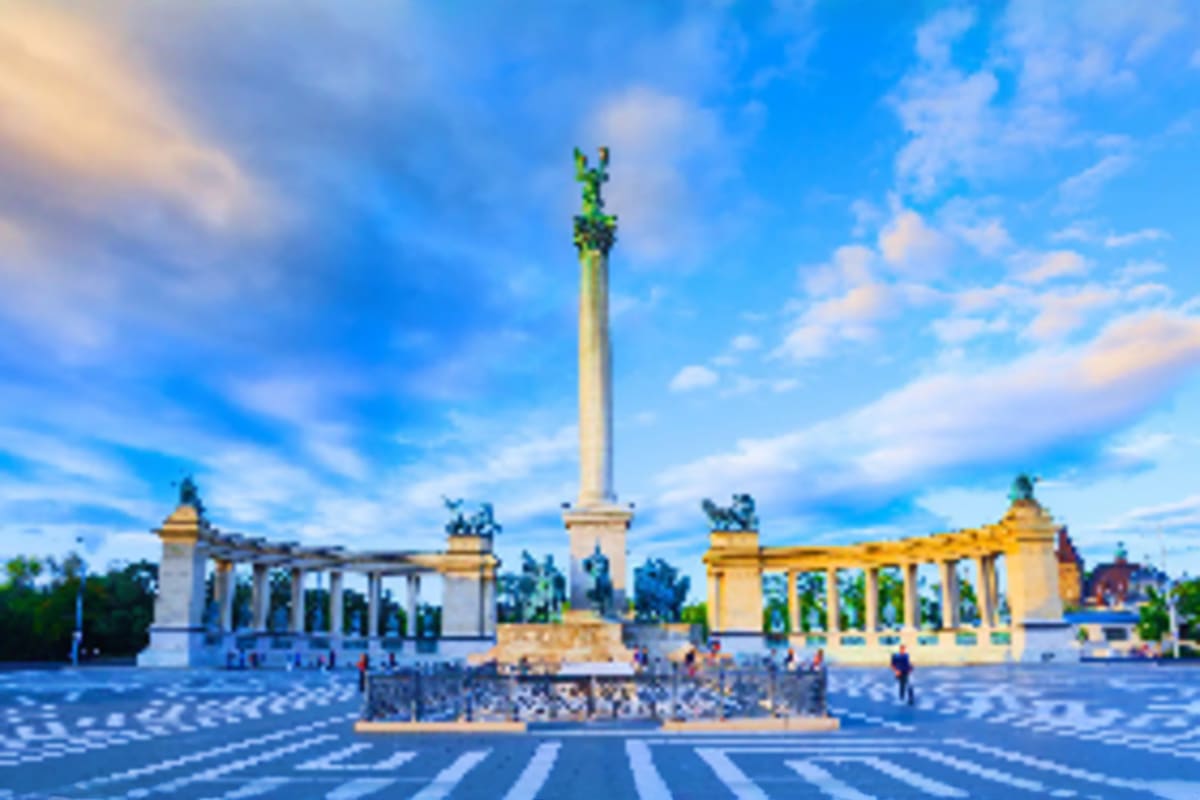 Heroes' Square in Budapest with central monument, colonnaded buildings and blue sky with clouds