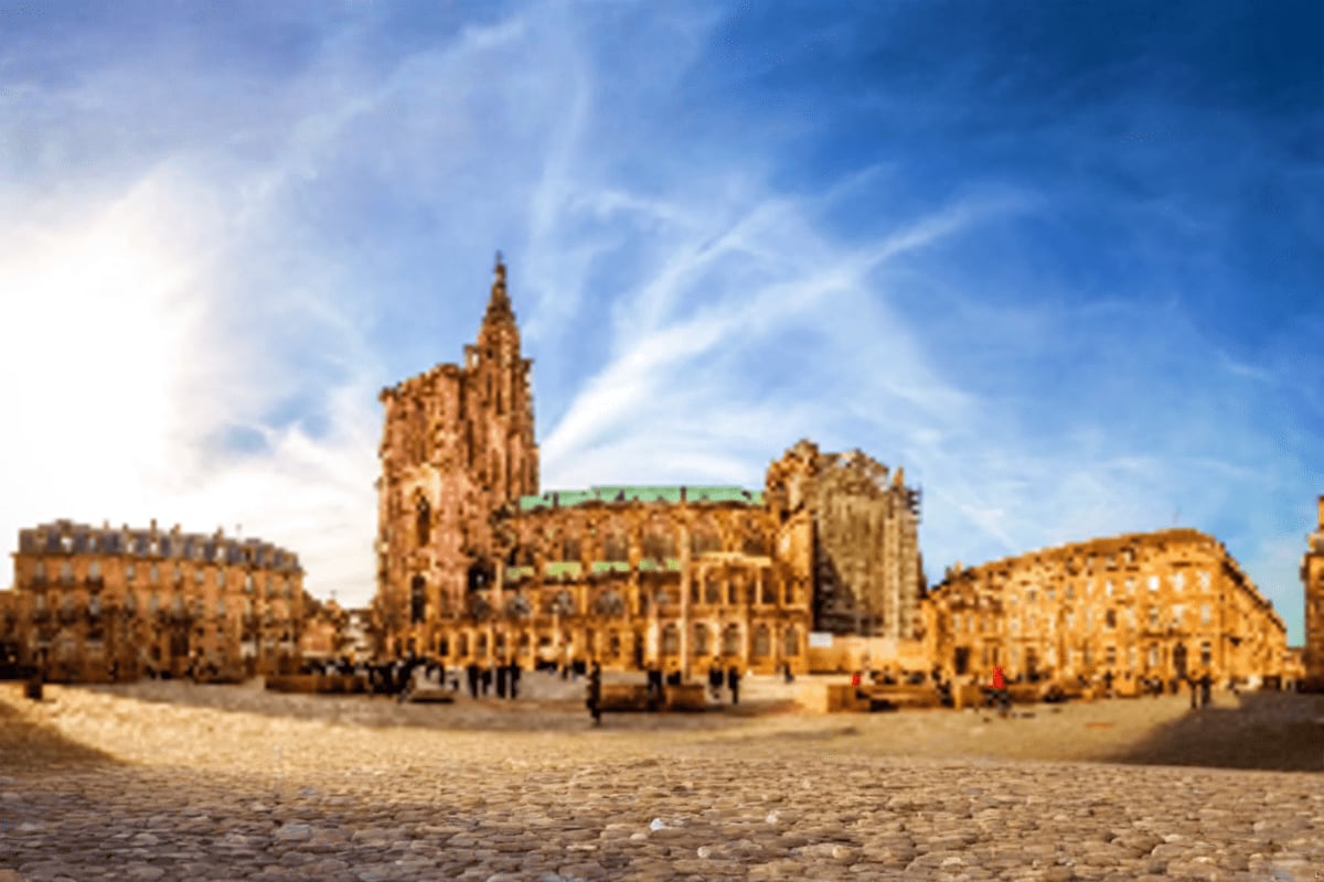 Strasbourg Cathedral and surrounding medieval buildings in Grand Île square under blue sky