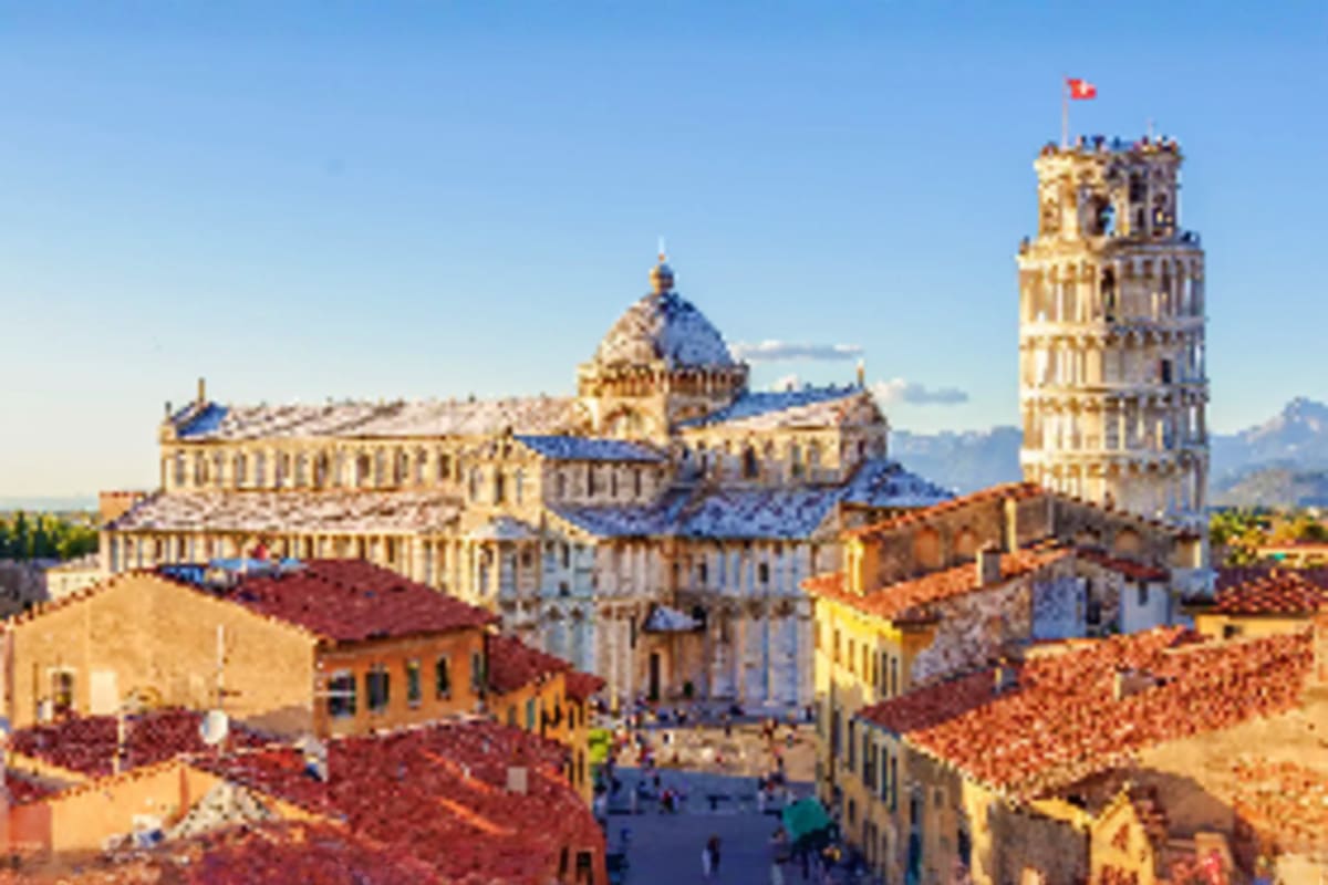 Historic cathedral with leaning bell tower in Italian piazza surrounded by colorful Renaissance buildings under blue sky