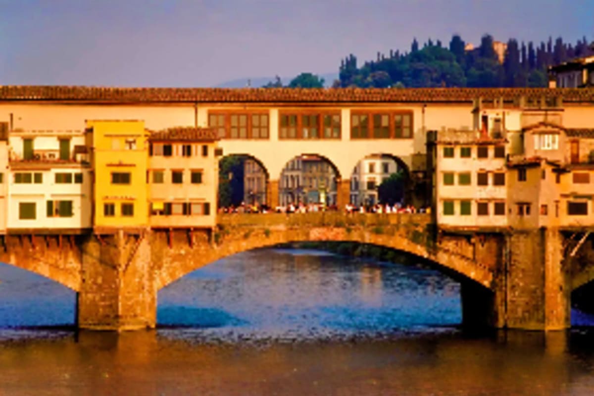 Ponte Vecchio bridge spanning the Arno River in Florence with historic buildings and shops built along its structure during g
