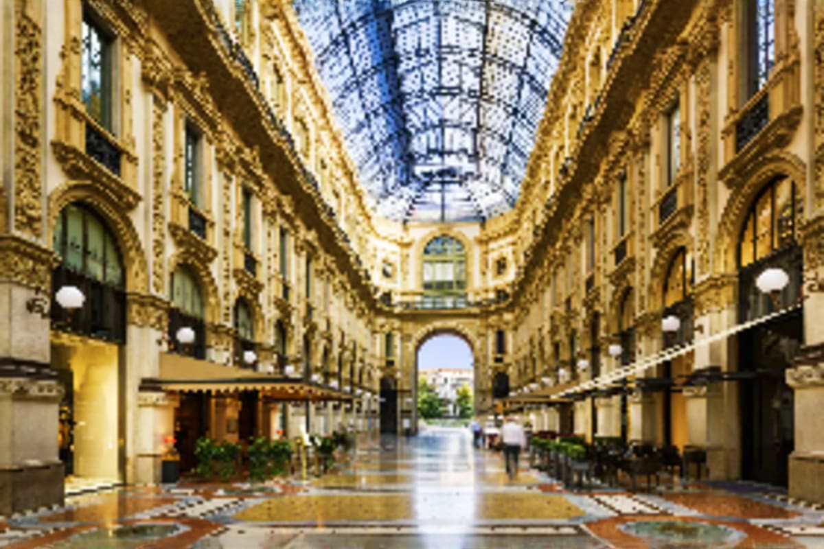 Ornate Parisian-style covered arcade with yellow stone buildings, glass roof, elegant storefronts and arched passageway