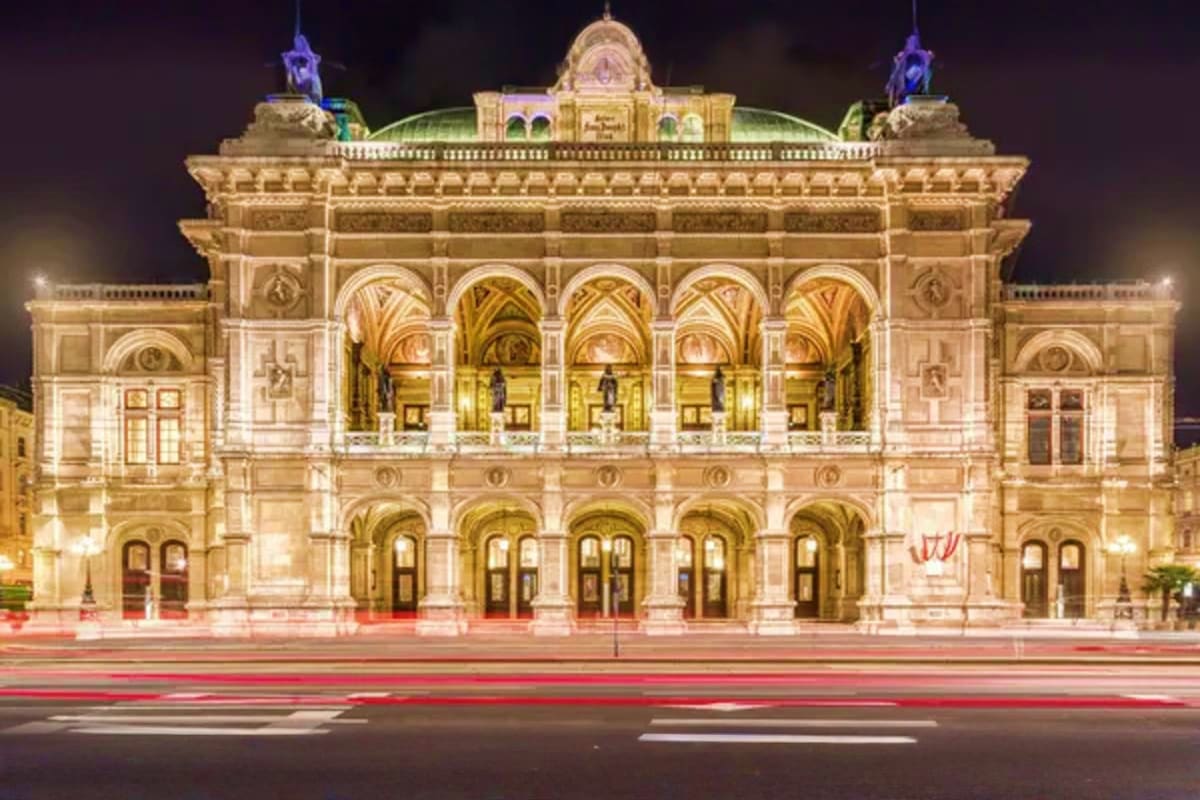 Vienna State Opera House illuminated at night with classical architecture and arched entrance hall