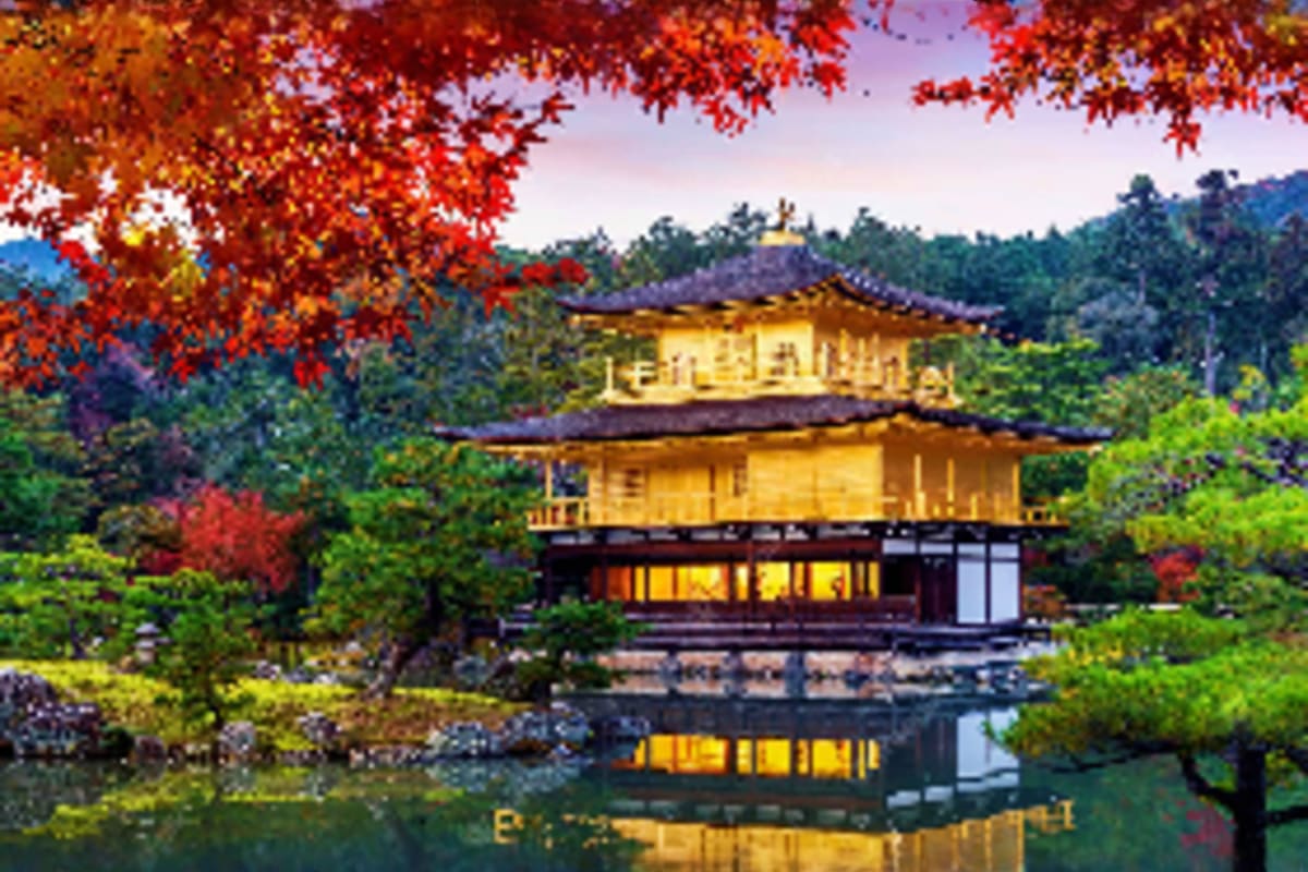 Essential Japan Tour Golden Pavilion temple with red autumn maple leaves reflecting in still pond, surrounded by green forest and mountains in Kyo