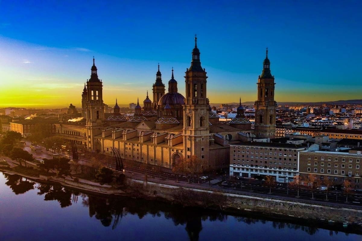 Basilica of Our Lady of the Pillar reflected in the Ebro River at sunset in Zaragoza, Spain