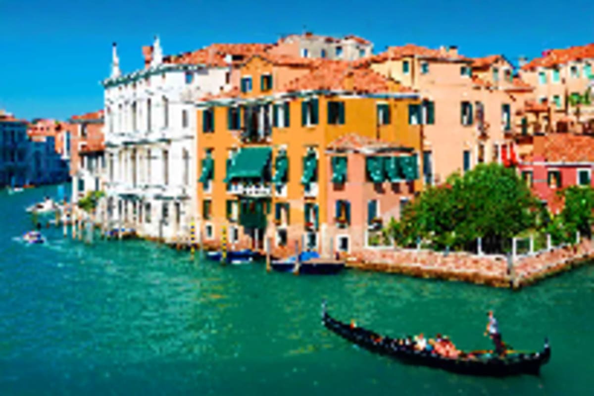 Glimpse of Europe Gondola on Grand Canal in Venice with colorful waterfront buildings and clear blue sky