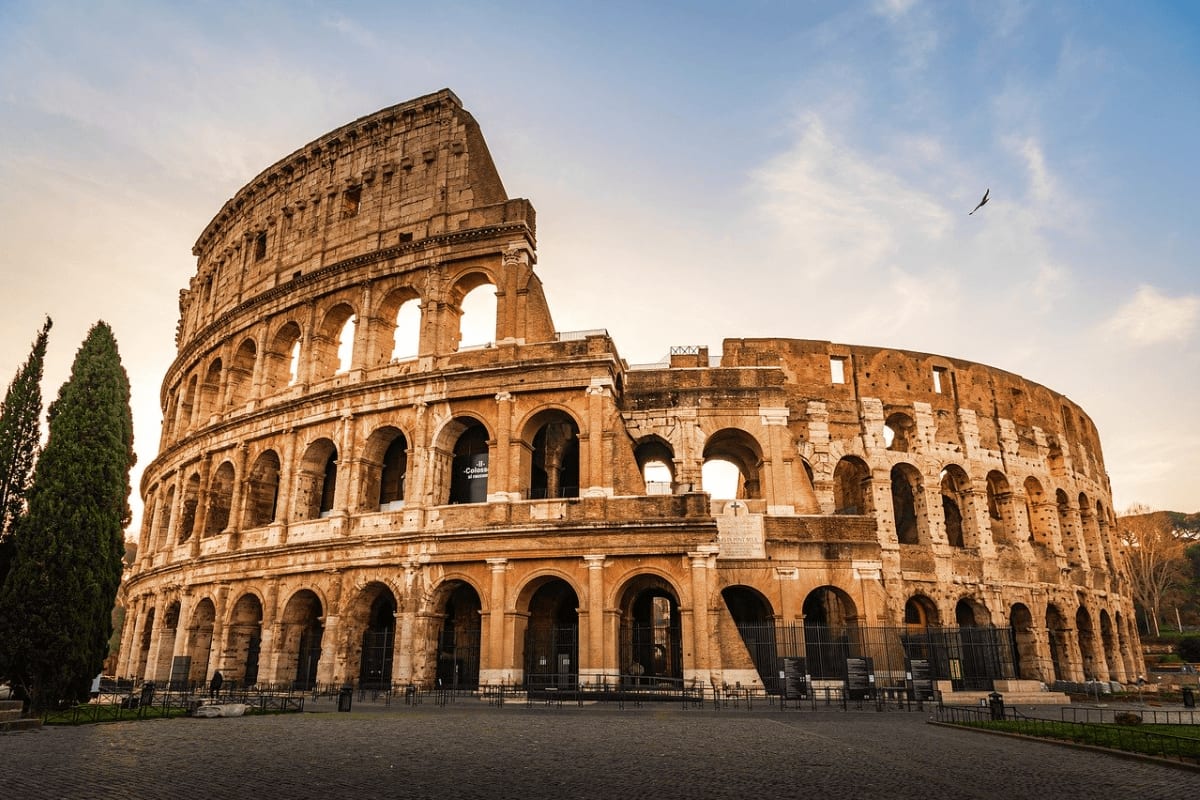 The Colosseum in Rome, Italy, an ancient Roman amphitheater with multiple tiers of arches and weathered stone architecture.