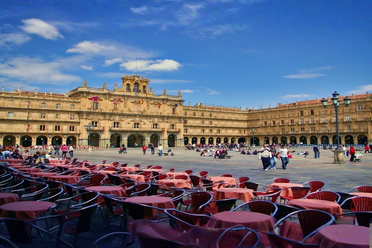 Historic plaza in Segovia Spain with Renaissance architecture, outdoor café seating, and tourists exploring the landmark squa