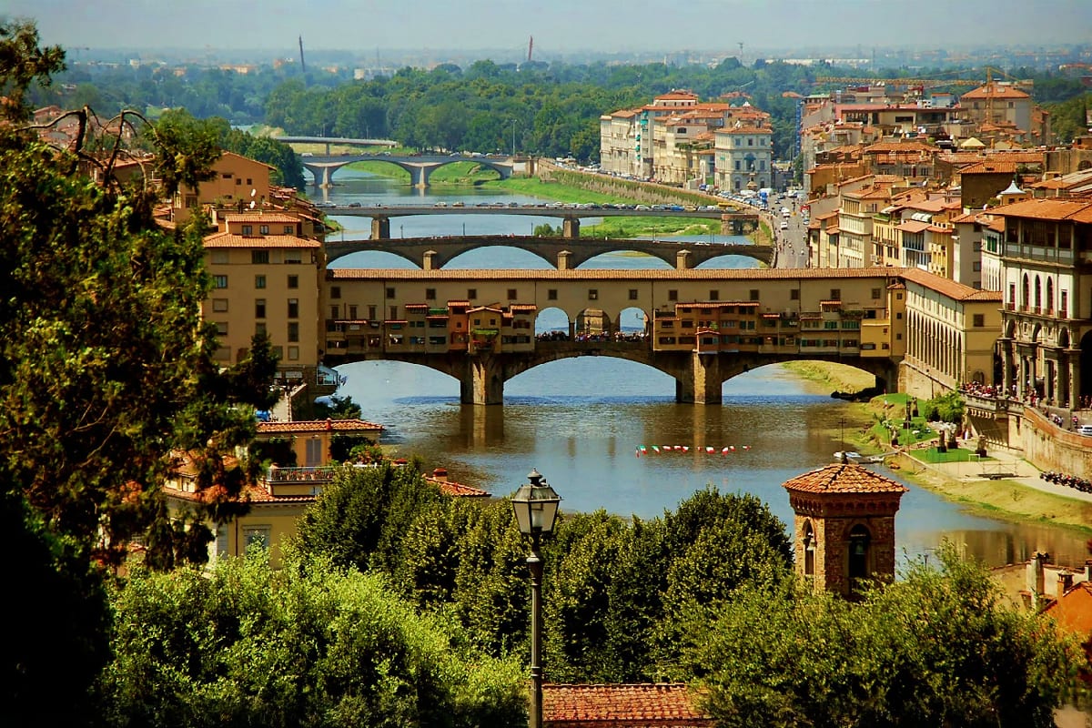 Italy Austria Budapest Journey Ponte Vecchio medieval bridge spanning the Arno River in Florence, Italy, with Renaissance buildings and multiple arches refl