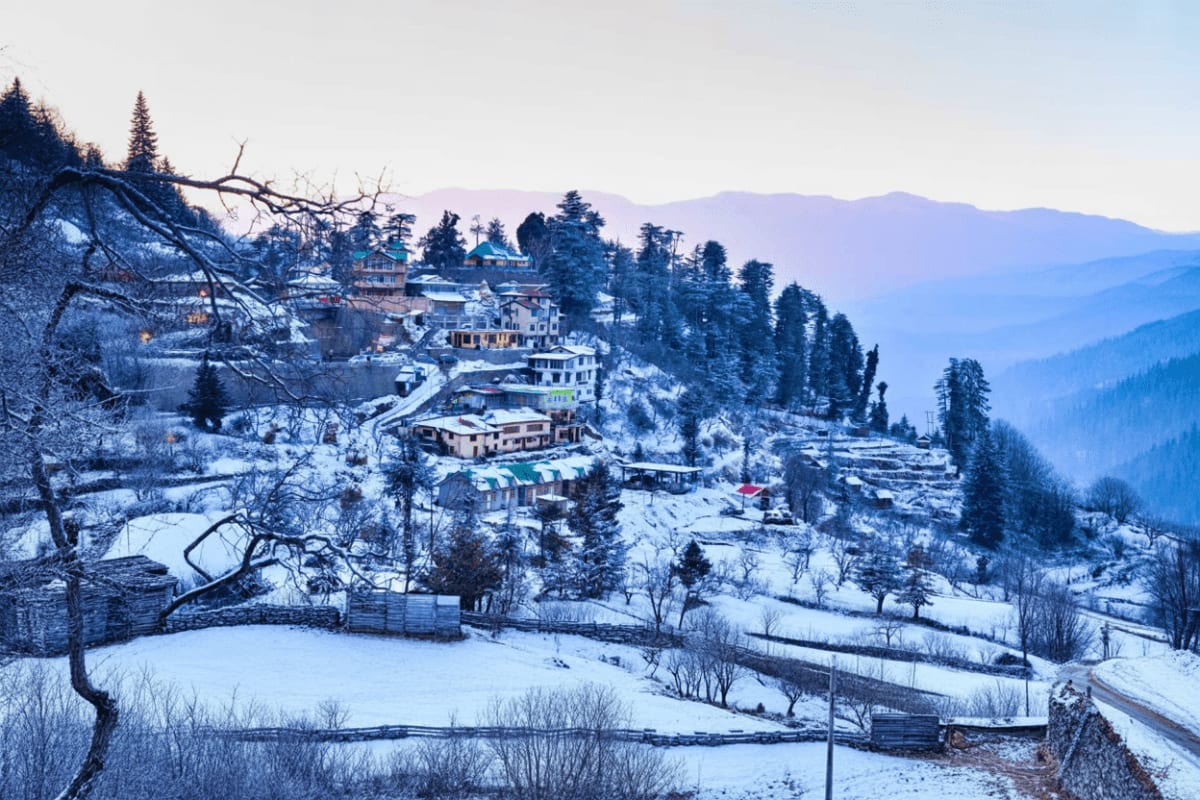 Snowy mountain village nestled on hillside with traditional buildings and evergreen trees in winter landscape
