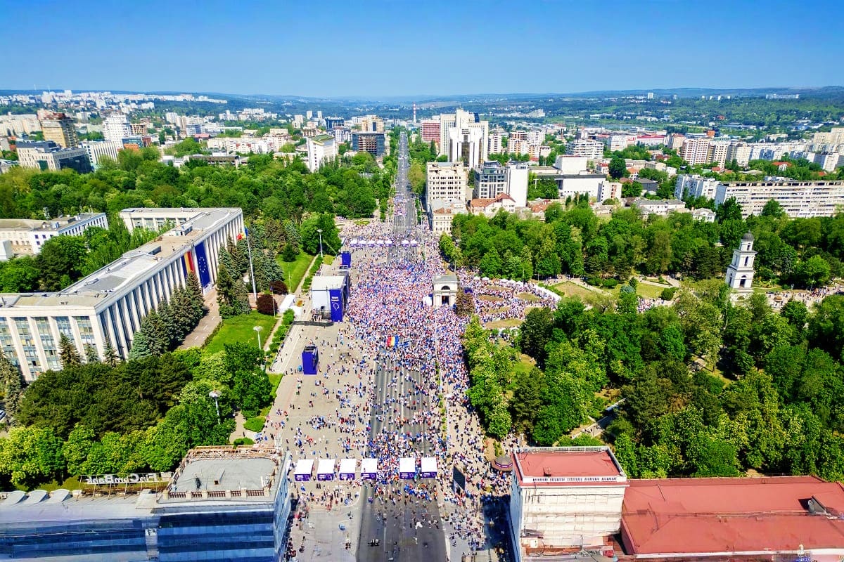 Aerial view of large public gathering on tree-lined boulevard in Armenian city during daytime celebration