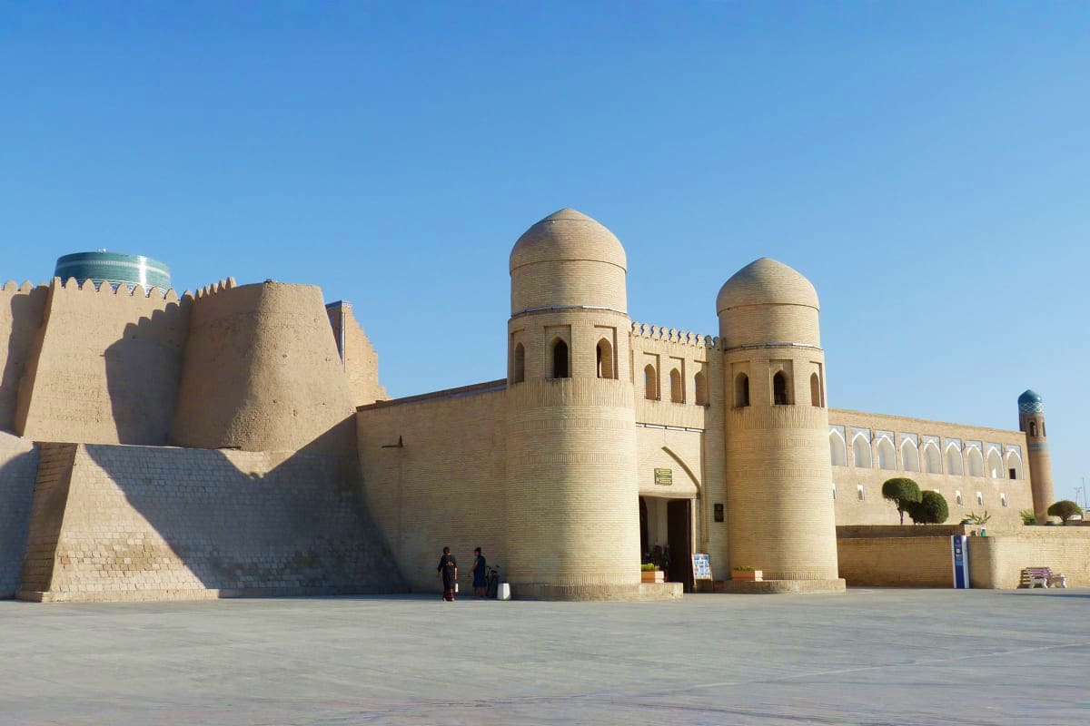 Ancient fortress with brick walls and two domed towers in Bukhara, Uzbekistan under clear blue sky