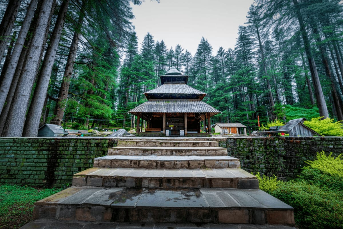 Himalayan Escape with Manali Temples and Solang Adventure Traditional tiered temple with wooden architecture nestled in dense coniferous forest, stone staircase leading upward, overca