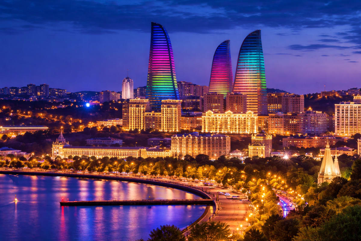 Baku city skyline at dusk with illuminated Flame Towers and waterfront promenade along the Caspian Sea