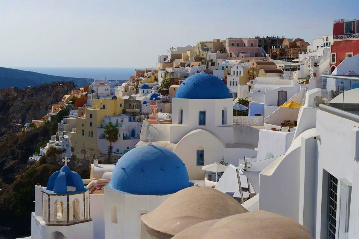 Santorini village with white-washed buildings and iconic blue-domed churches overlooking the Aegean Sea