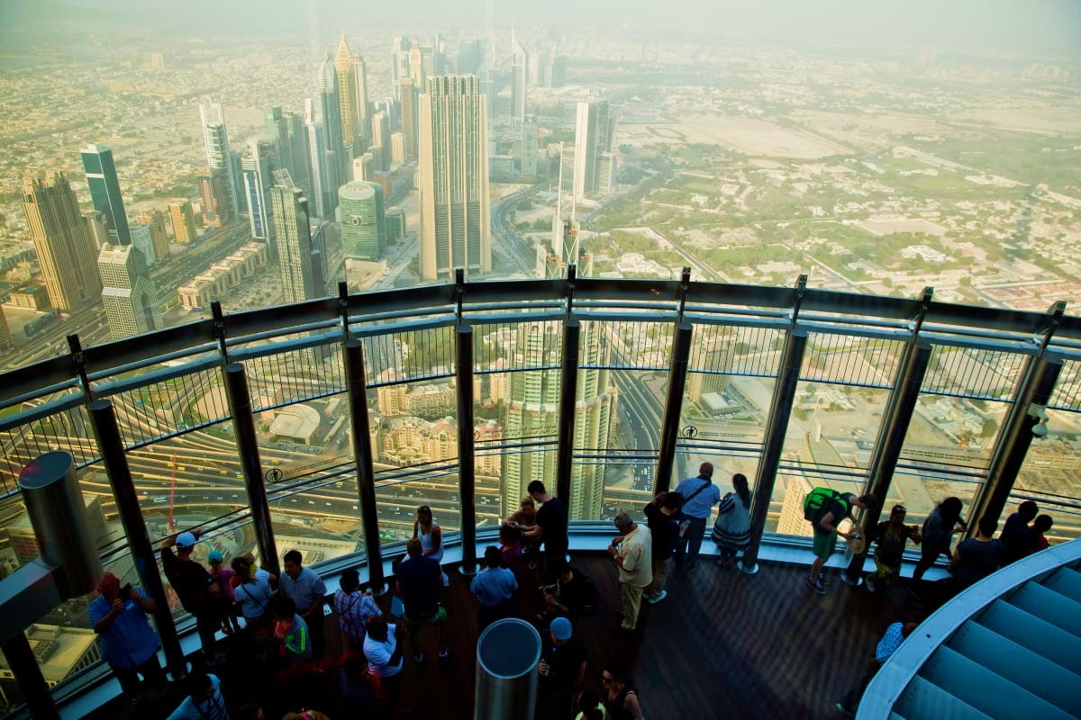 Visitors on observation deck of Burj Khalifa with panoramic views of Dubai skyline and surrounding cityscape