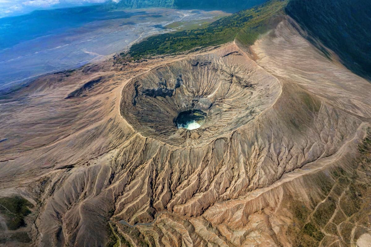 Aerial view of Mount Damavand crater with sulfur lake, showing volcanic cone and surrounding barren landscape in Azerbaijan