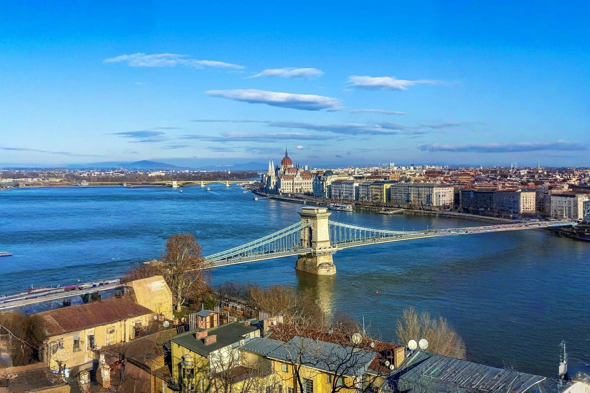 Chain Bridge spanning the Danube River with Hungarian Parliament Building and Budapest cityscape on a clear day