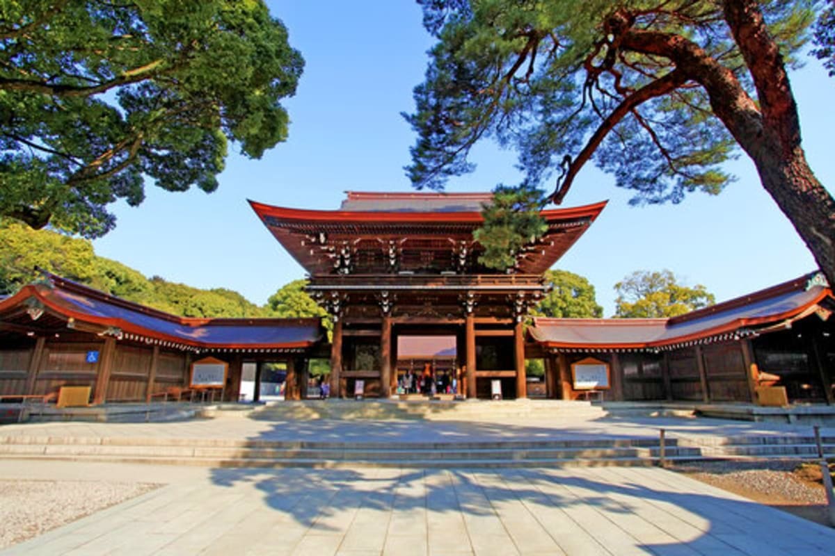 Central Japan Traditional Japanese temple with red-trimmed roofs, wooden gates, and mature trees in a serene courtyard setting under clear