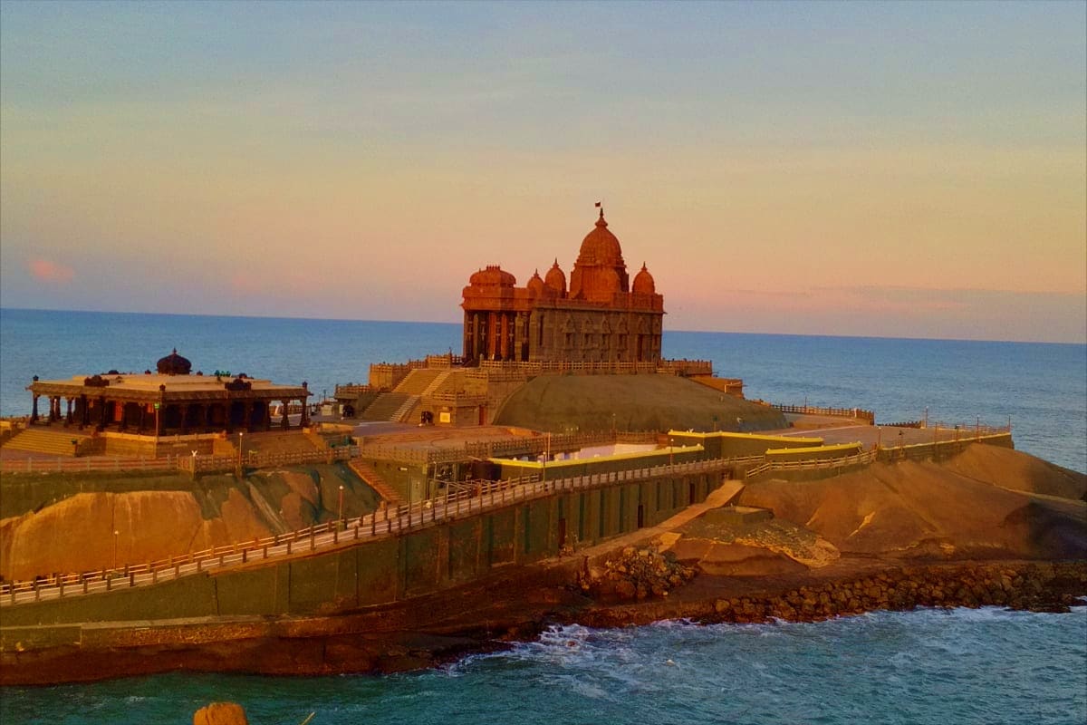 Vivekananda Rock Memorial temple at sunset in Kanyakumari, surrounded by ocean waters and coastal landscape