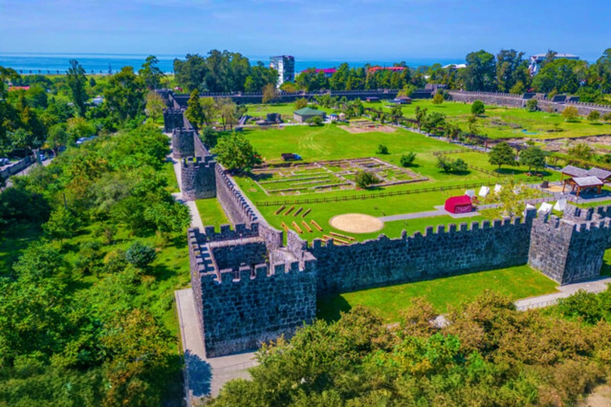 Aerial view of Fortress of Narikala with stone walls, green grounds, and Black Sea coastline in Tbilisi, Georgia