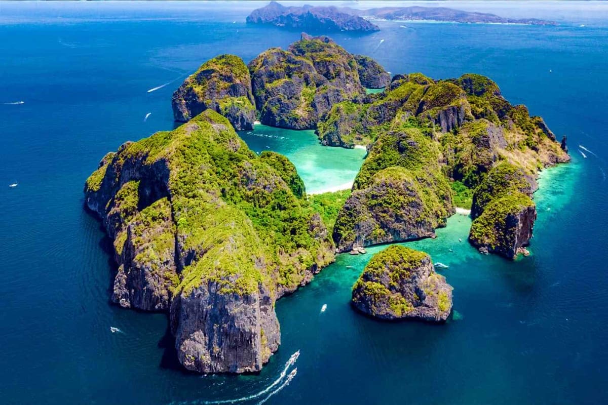 Aerial view of Phi Phi Islands limestone cliffs with turquoise lagoon and emerald waters in Thailand