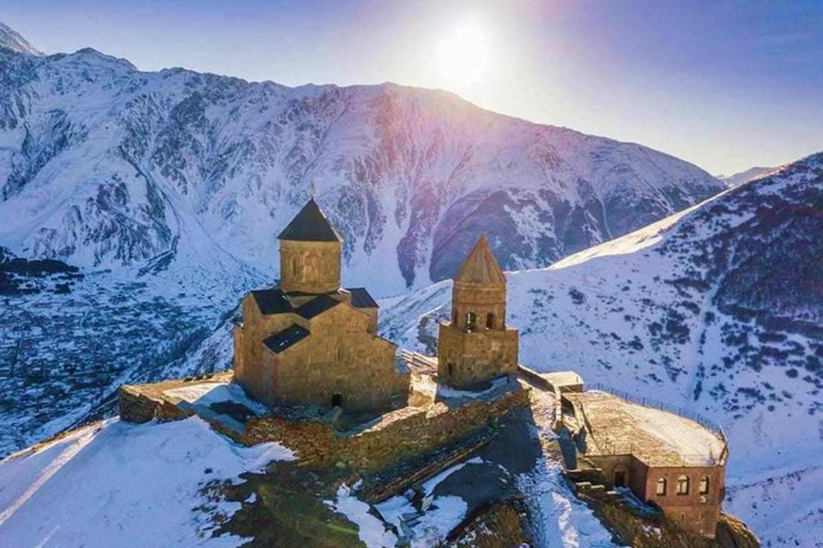 Akdamar Church with twin stone domes surrounded by snow-covered mountains in winter, Georgia