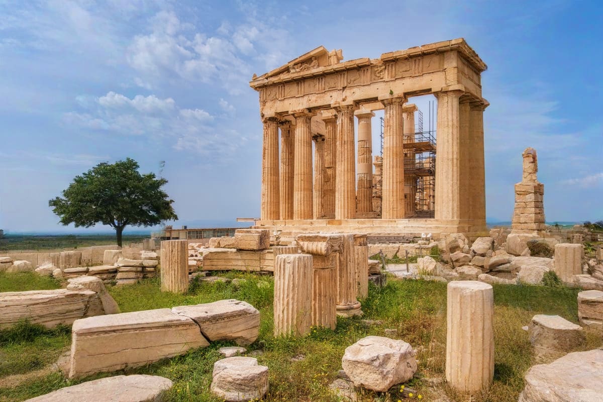 Ancient Greek temple ruins with Doric columns on a hilltop overlooking coastal landscape with scattered stone fragments and g