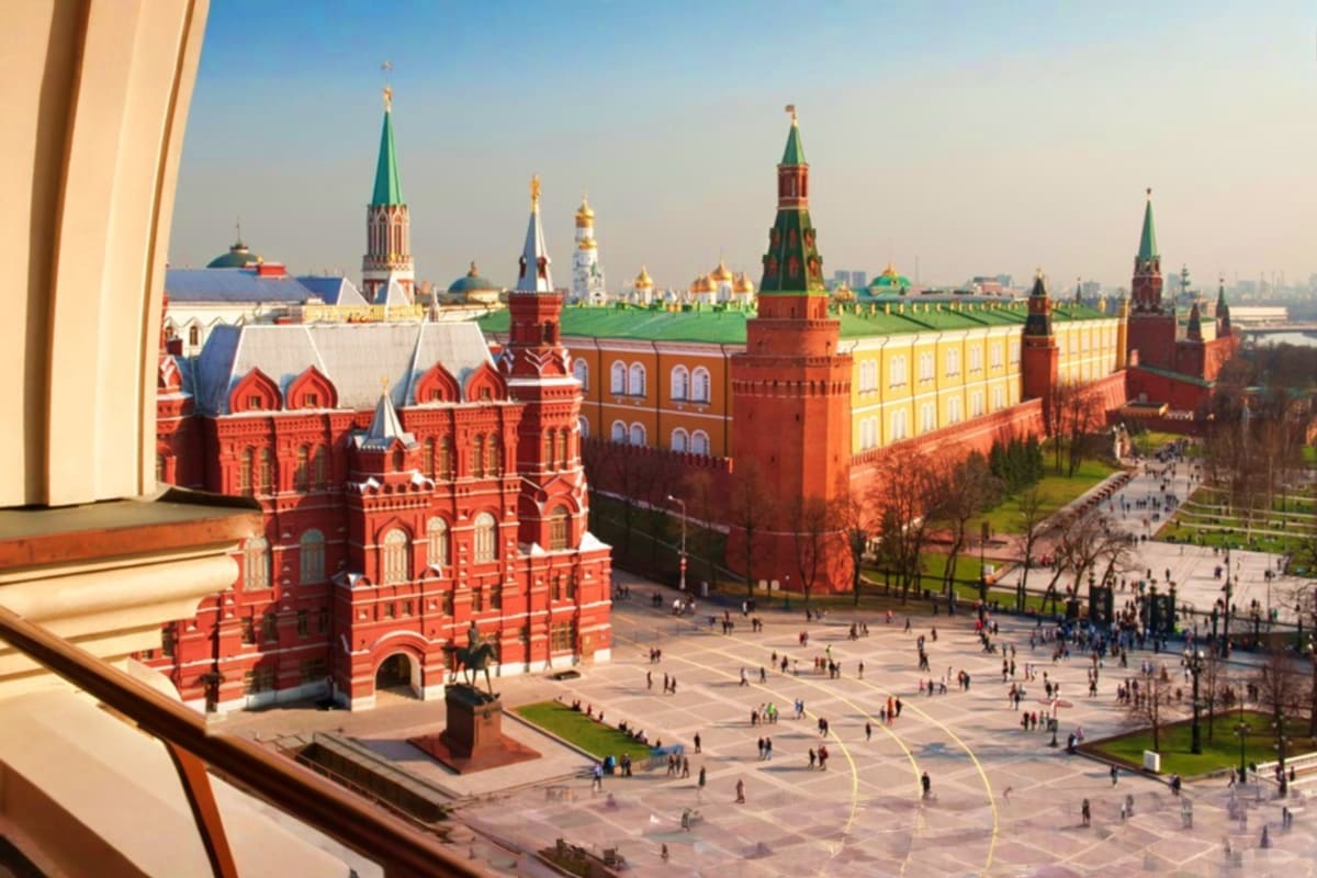 Aerial view of Moscow's Red Square showing historic red brick buildings, the Kremlin walls, and golden-domed churches with to
