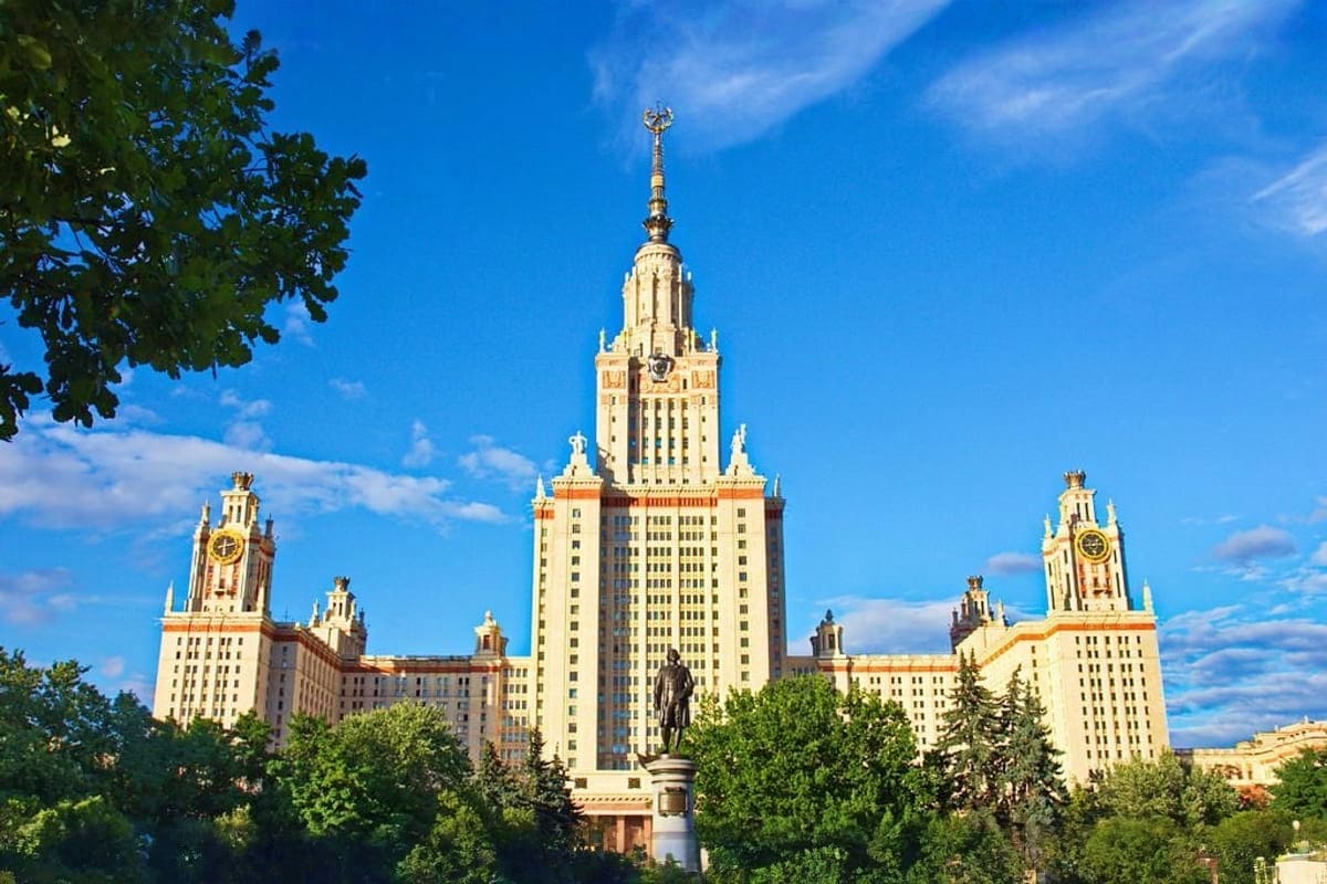 Moscow State University main building with golden spires and ornate Stalinist architecture against blue sky and surrounding t