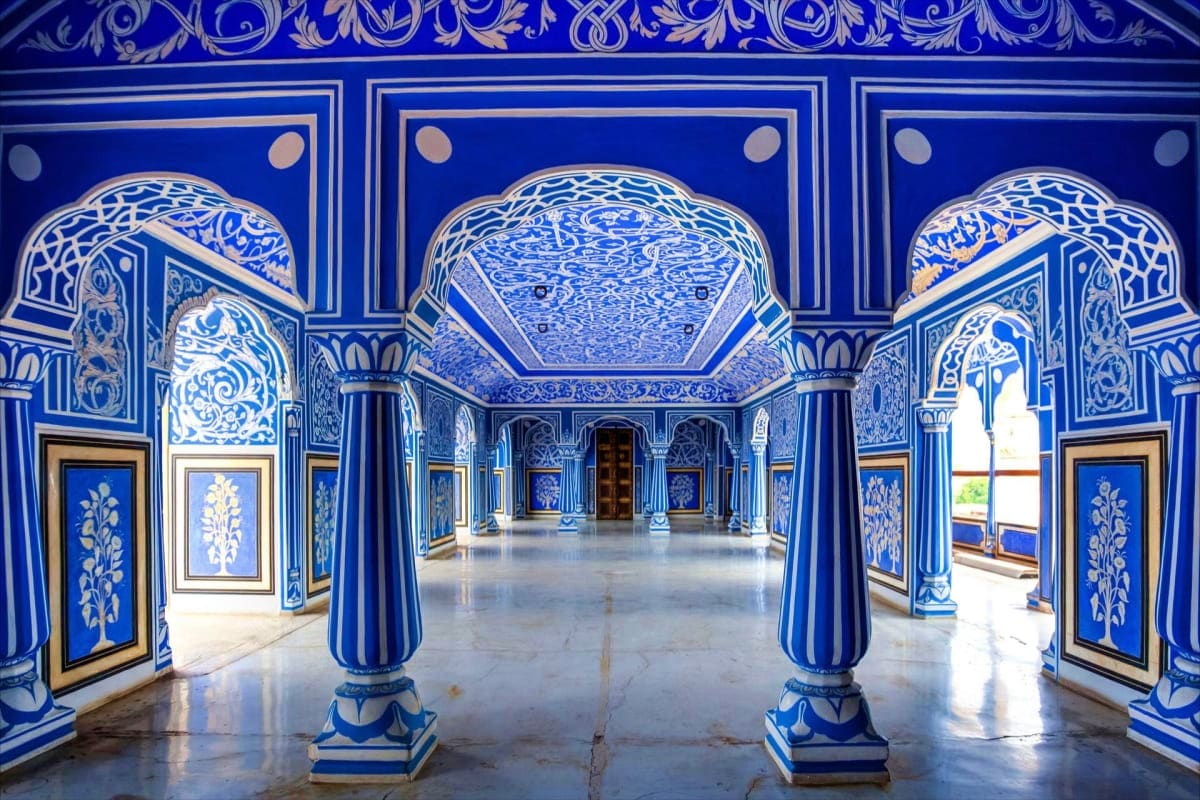 Blue and white ornamental palace corridor with striped columns, intricate tilework, and decorative archways in traditional In