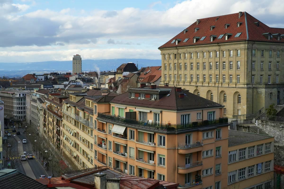 Elevated view of Lucerne city skyline with colorful residential buildings, historic architecture, and Alpine mountains in the