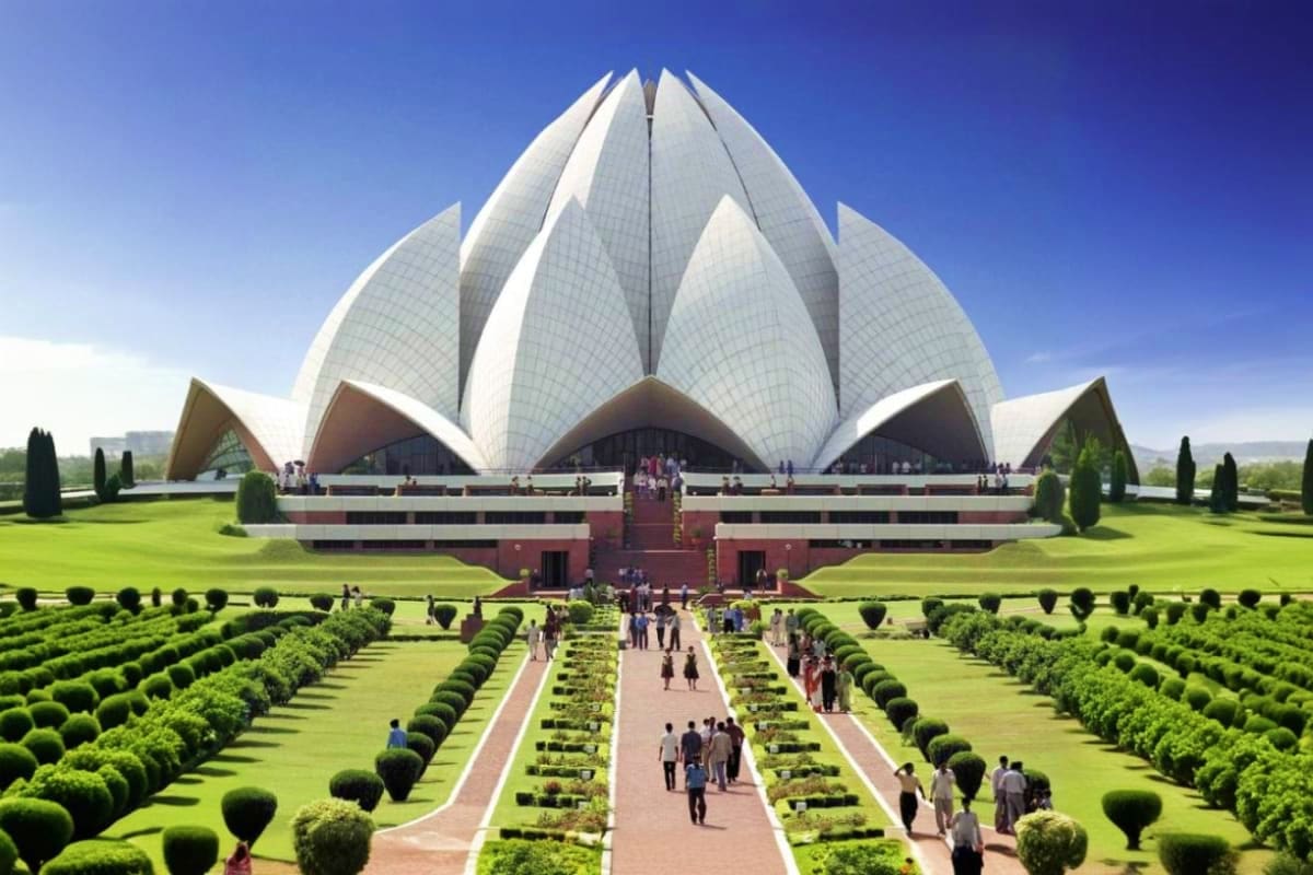 Lotus Temple in Delhi with white marble petals, symmetrical gardens, and visitors walking along the central pathway under cle