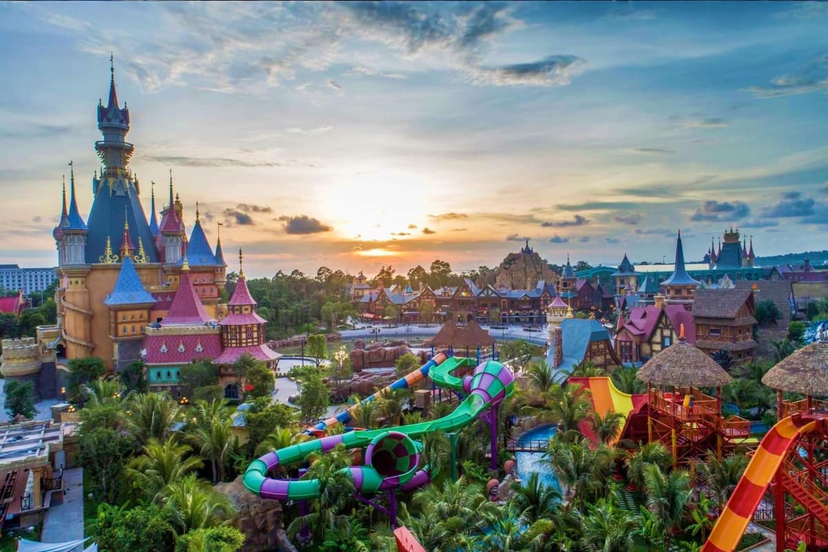 Aerial view of fairy tale castle and colorful water slides at theme park during sunset, Vietnam
