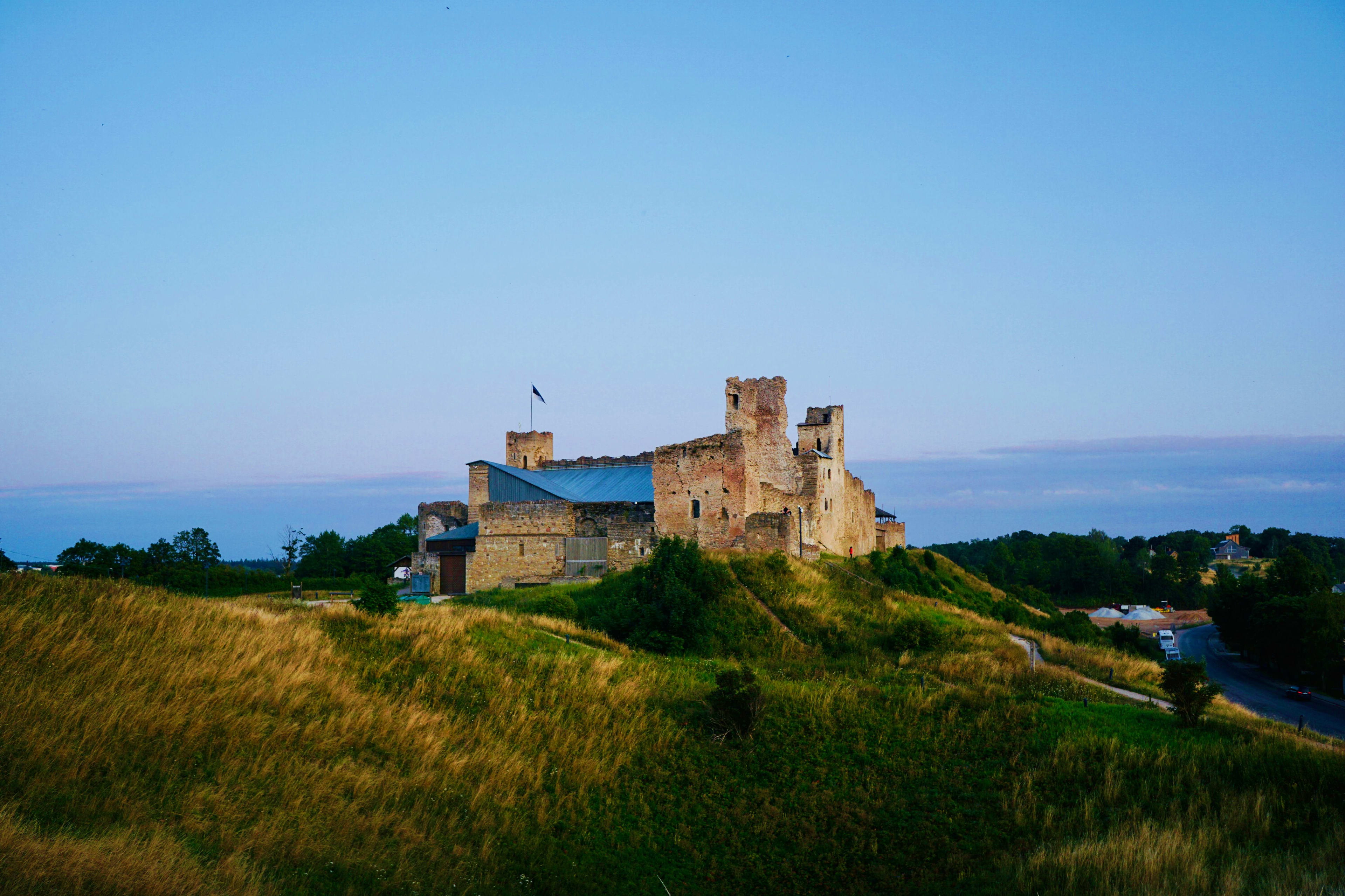 Estonia Lohesalu Castle ruins perched on a grassy hilltop in Estonia, with blue sea and sky in background