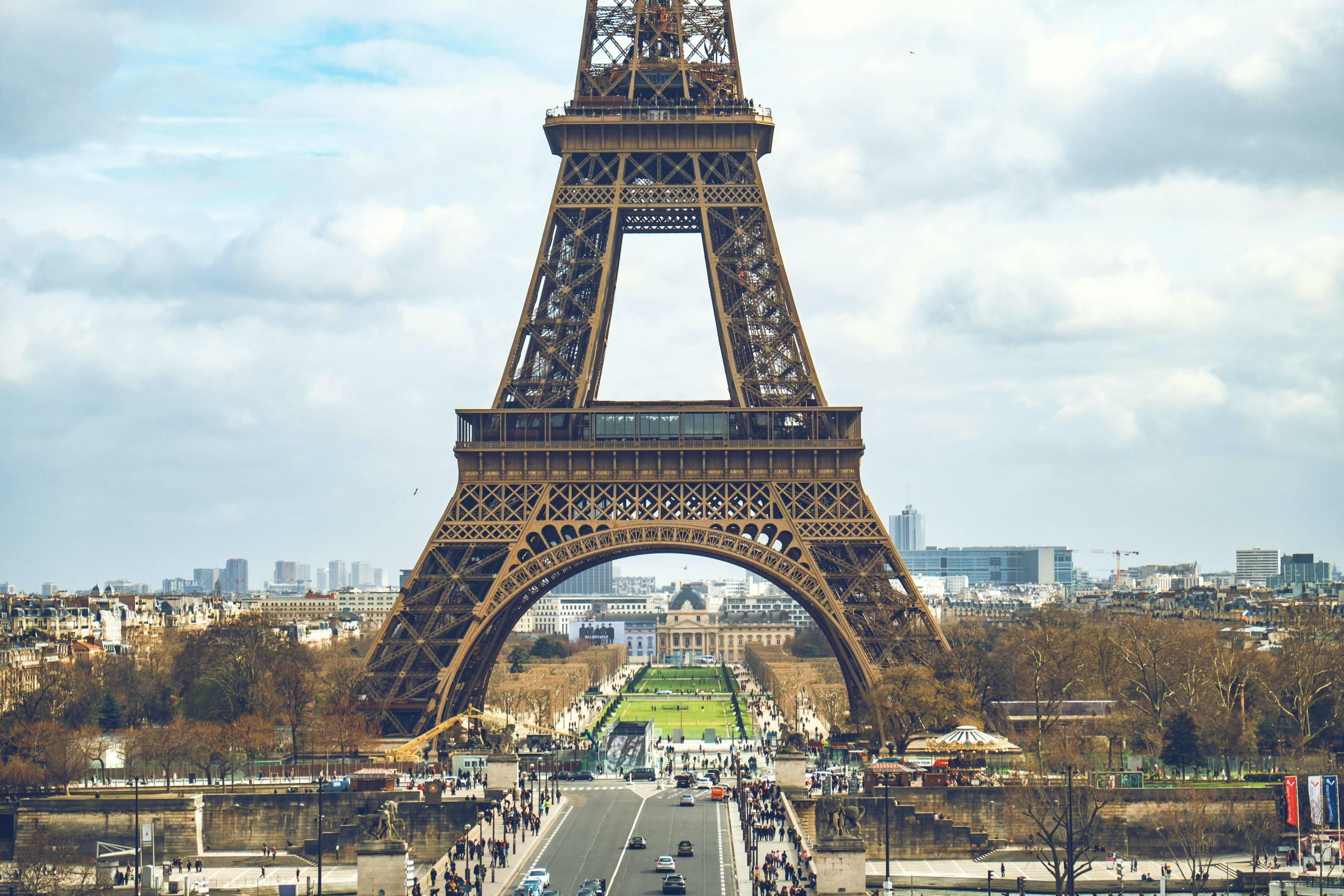France Eiffel Tower in Paris with Champ de Mars gardens and city skyline visible through the iron lattice structure