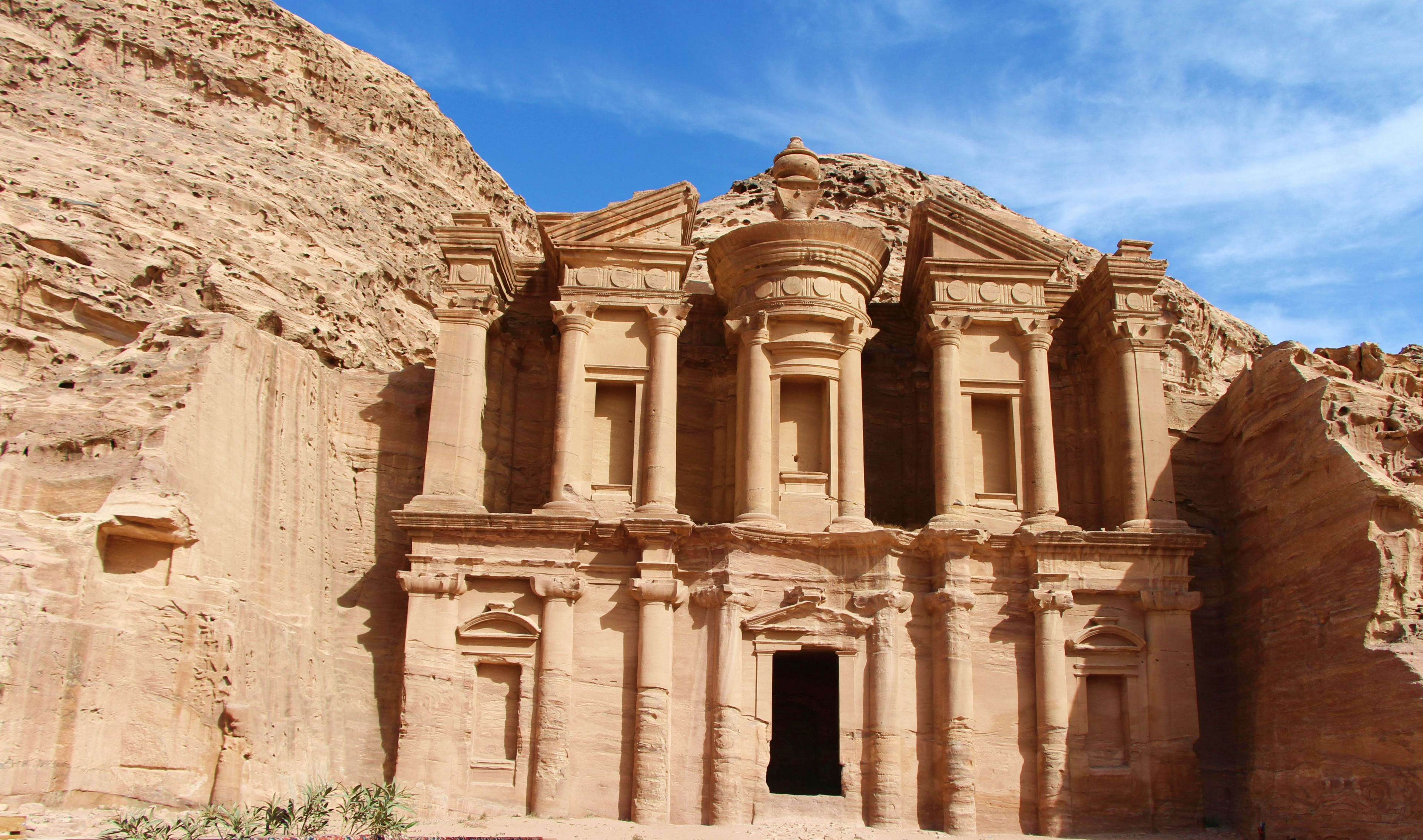 Jordan The Monastery at Petra, a massive carved sandstone temple facade with ornate columns and capitals set into a desert cliff fac
