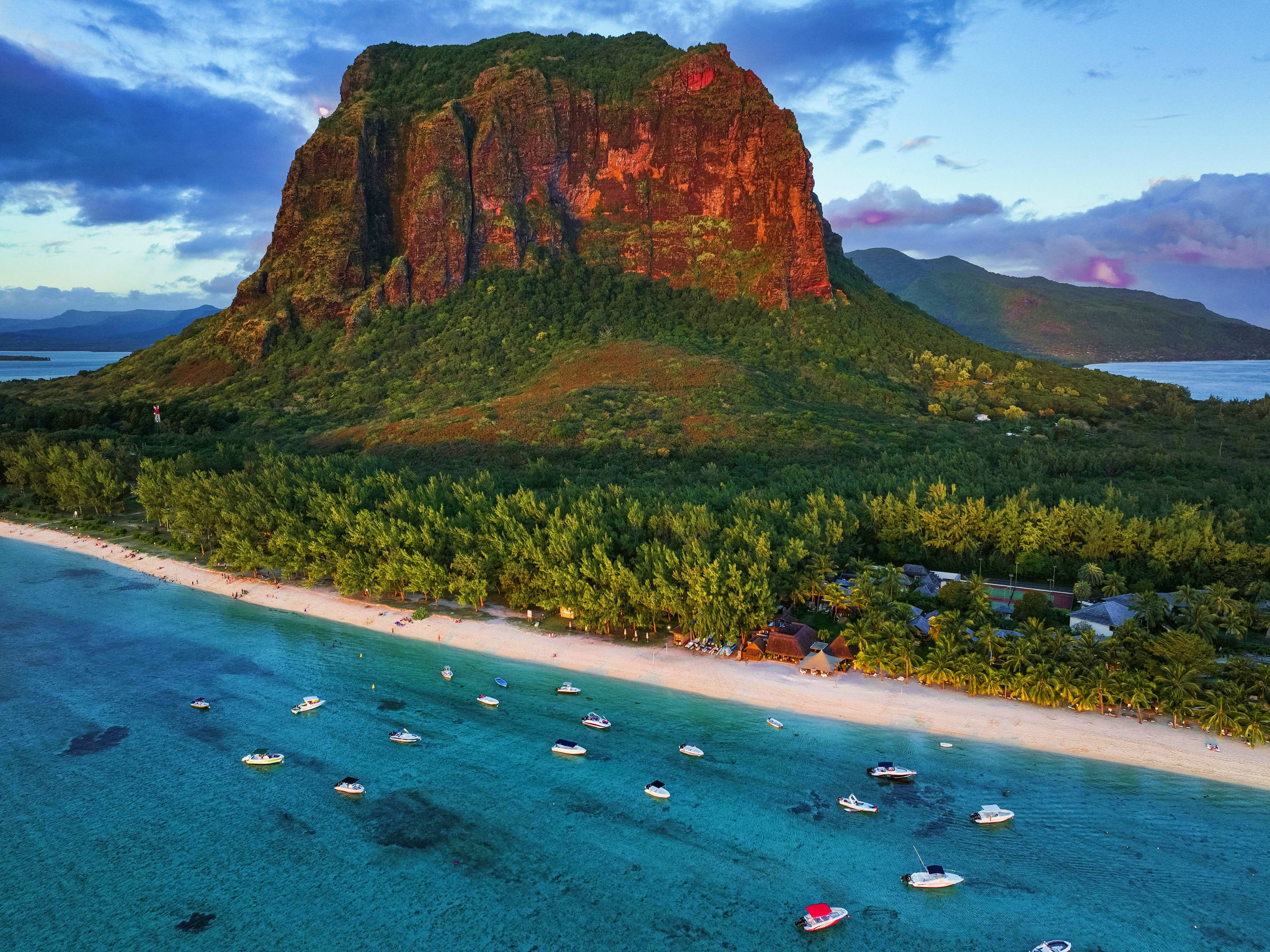 Mauritius Aerial view of Le Morne Brabant mountain with turquoise lagoon, sandy beach, and moored boats in Mauritius
