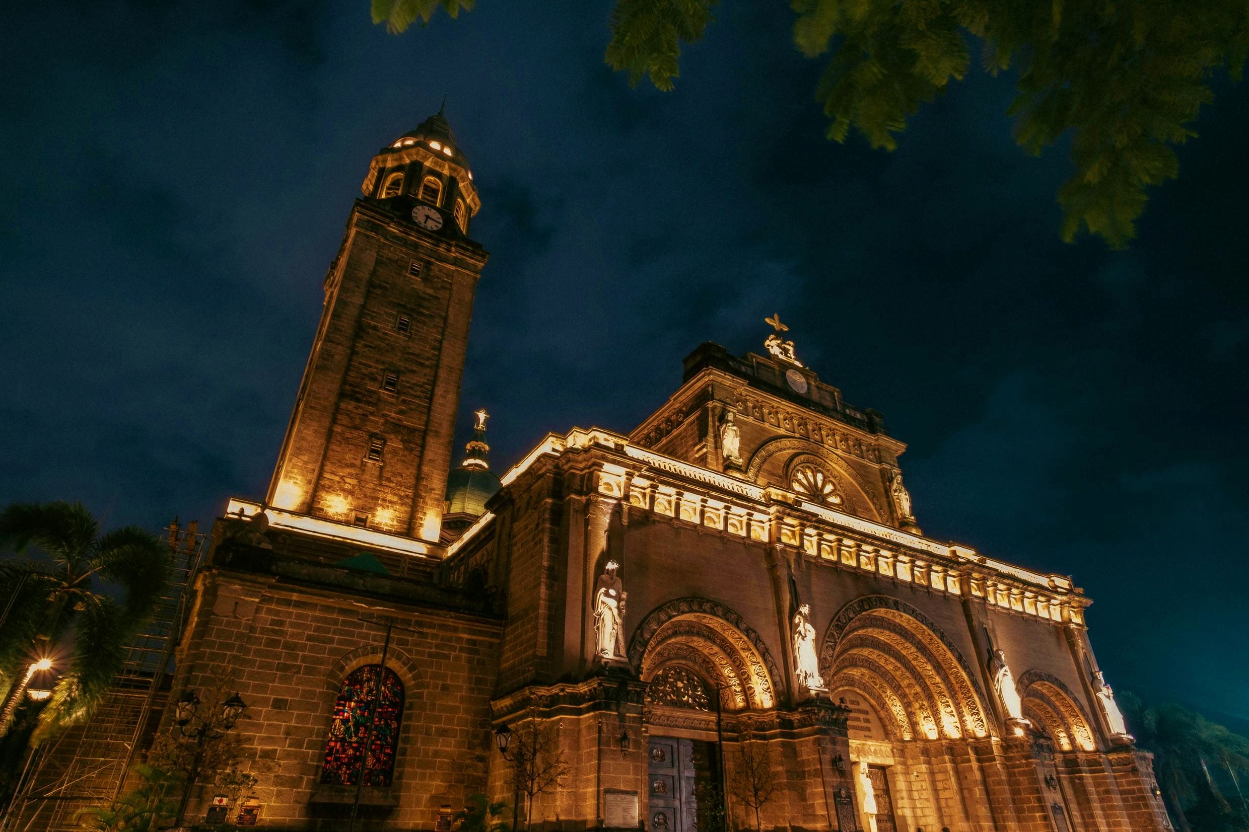 Philippines Illuminated historic church with tall bell tower and ornate stone facade at night in the Philippines
