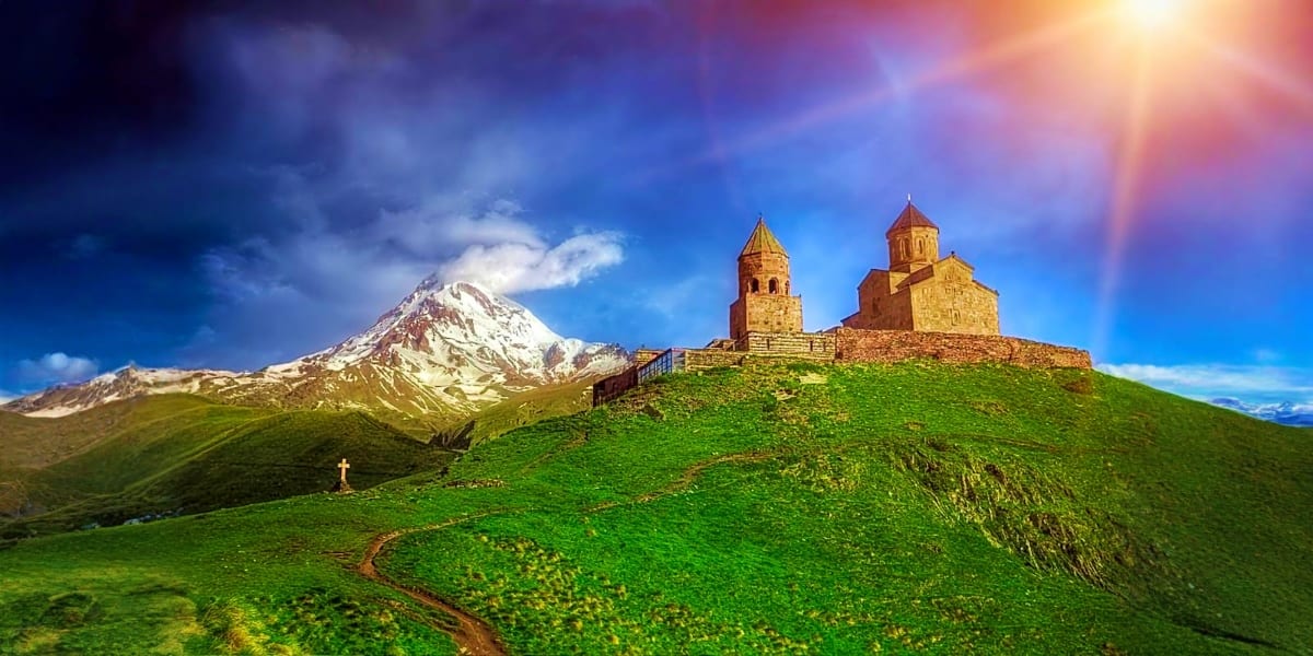 Kackar Church with snow-capped Mount Ararat in the background, green hillside landscape in Armenia
