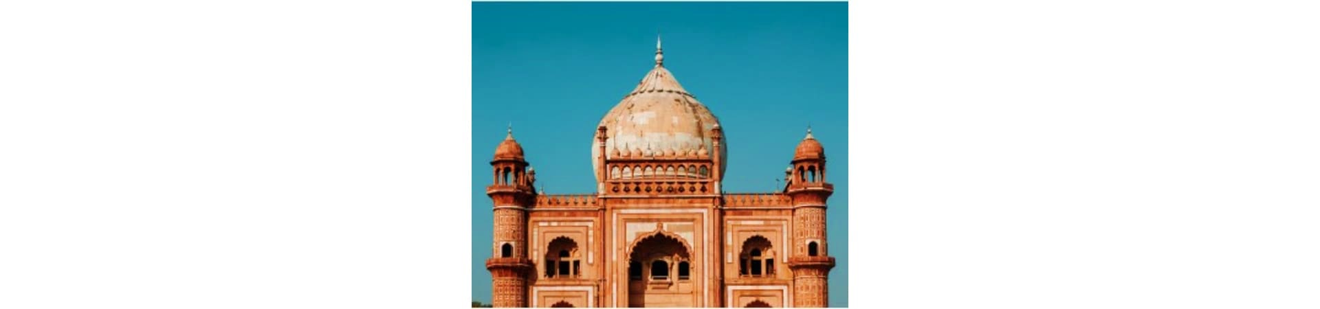 Historic red sandstone mosque with large dome and minarets against clear blue sky in Delhi, India